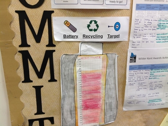 A battery recycling target sign on a school noticeboard