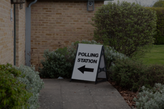 A polling station sign next to a building
