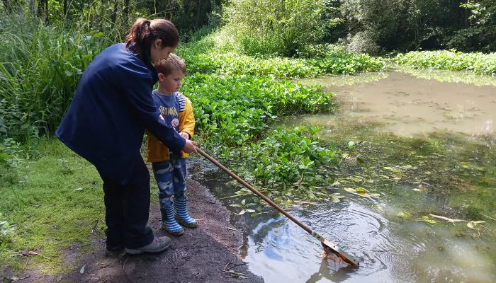 Bella Sabine-Dawson helping a young child get their net into a pond