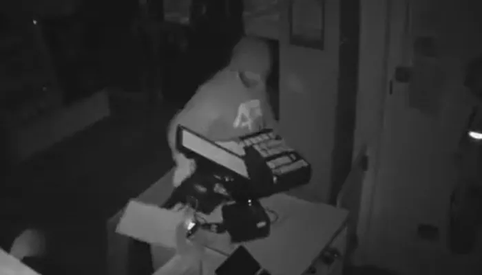 CCTV still showing man snatching the till