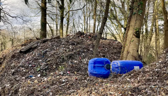 Hoad's wood fly tipping pile with blue plastic containers in foreground