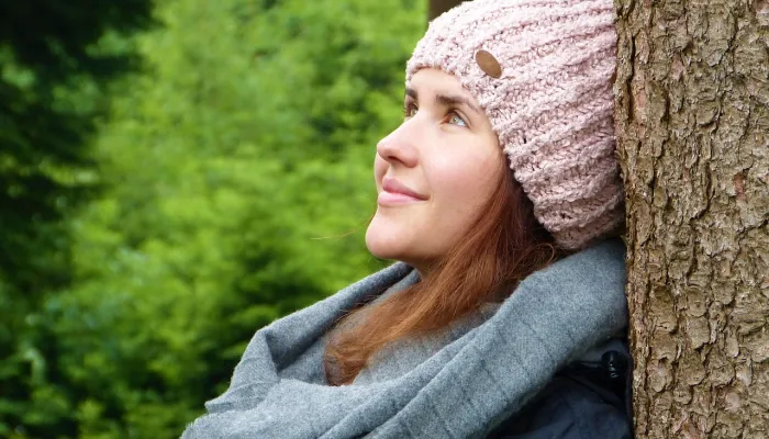 Woman sitting against a tree