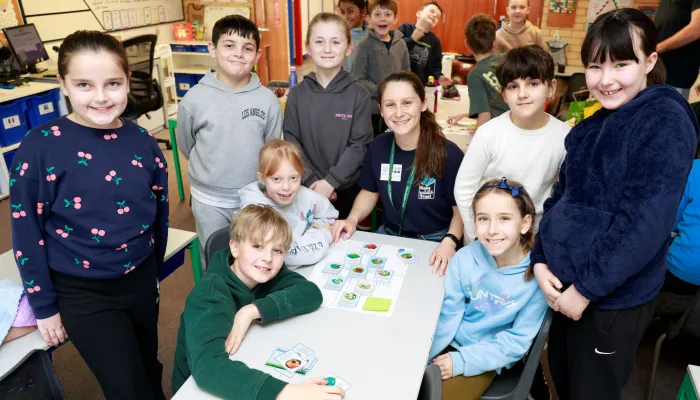 A group of children and a tutor sat at a table taking part in an action plan workshop. 