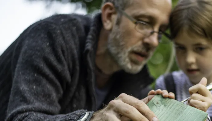 A man and a young girl building a wildlife home together
