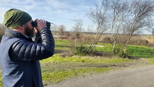 Paul Hadaway looking out at bettesehanger country park with his binoculars to his face