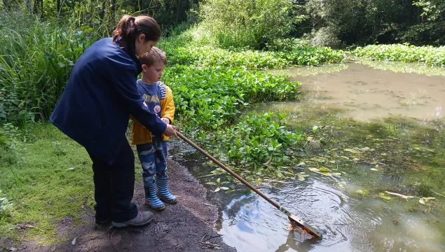 Bella Sabine-Dawson helping a young child get their net into a pond