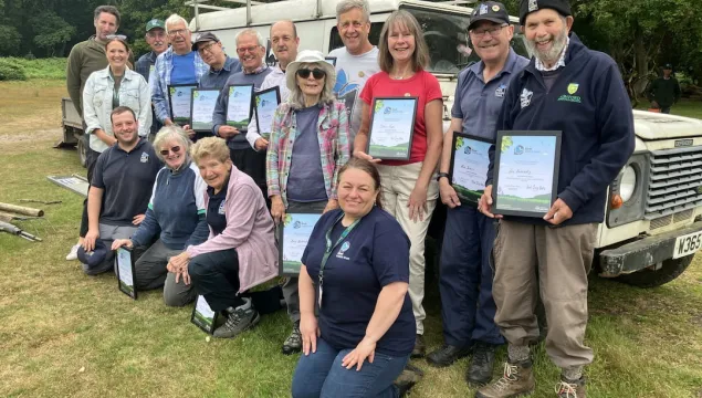 A group of Ashford Kent Wildlife Trust volunteers standing with their Wilder Kent Award certificates.