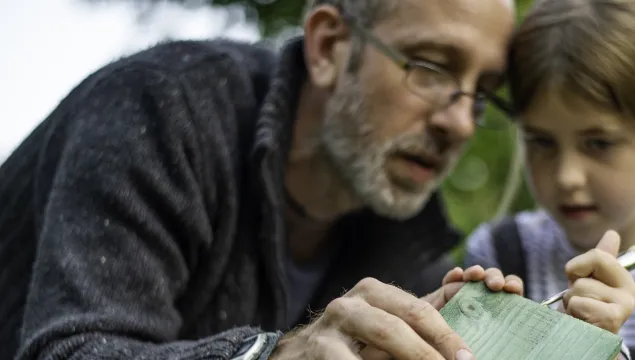 A man and a young girl building a wildlife home together