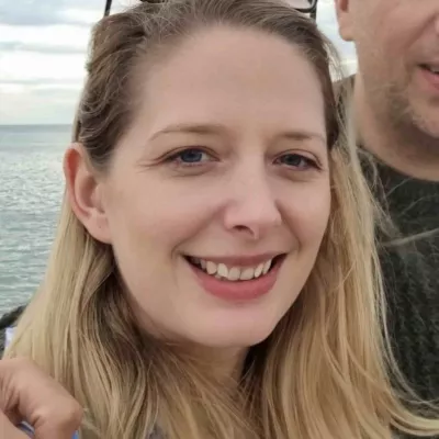 A profile photo of Hollie Du Preez, Head of Strategic Conservation Initiatives, in front of the sea.