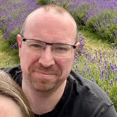 A profile picture of Trustee, Jon Kirkpatrick, in front of a lavender field.