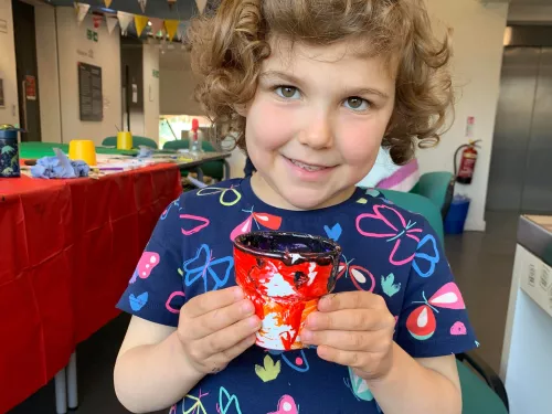 Child holding painted pot