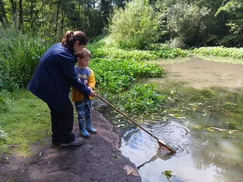 Bella Sabine-Dawson helping a young child get their net into a pond