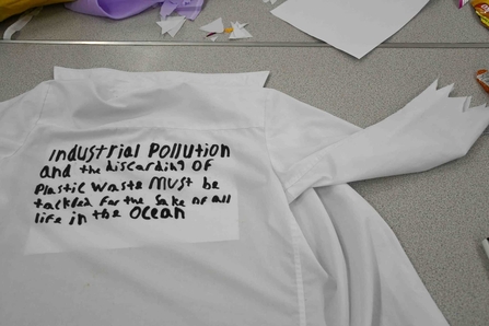 A shirt with writing on that says 'industrial pollution... must be tackled for the sake of all our life in the ocean'