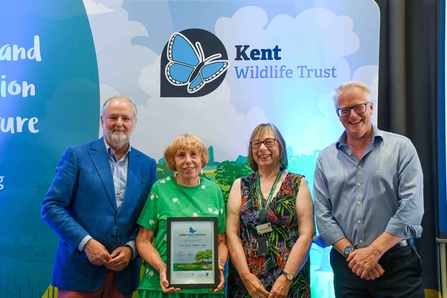 Wild About Gardens Team standing with a Wilder Kent Volunteer Award certificate.