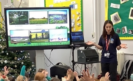 Education tutor Bella showing a presentation to a class on a TV