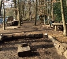 A forest school area equipped with log benches and tables